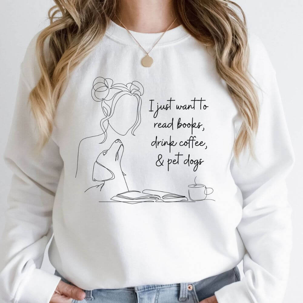 Woman wearing a sweatshirt that reads I just want to read books, drink coffee, and pet dogs